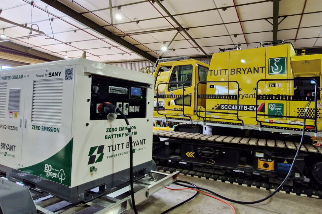 SANY SPL210 BESS recharging a SANY SCC400TB-EV Electric Crawler Crane on in an indoor warehouse.